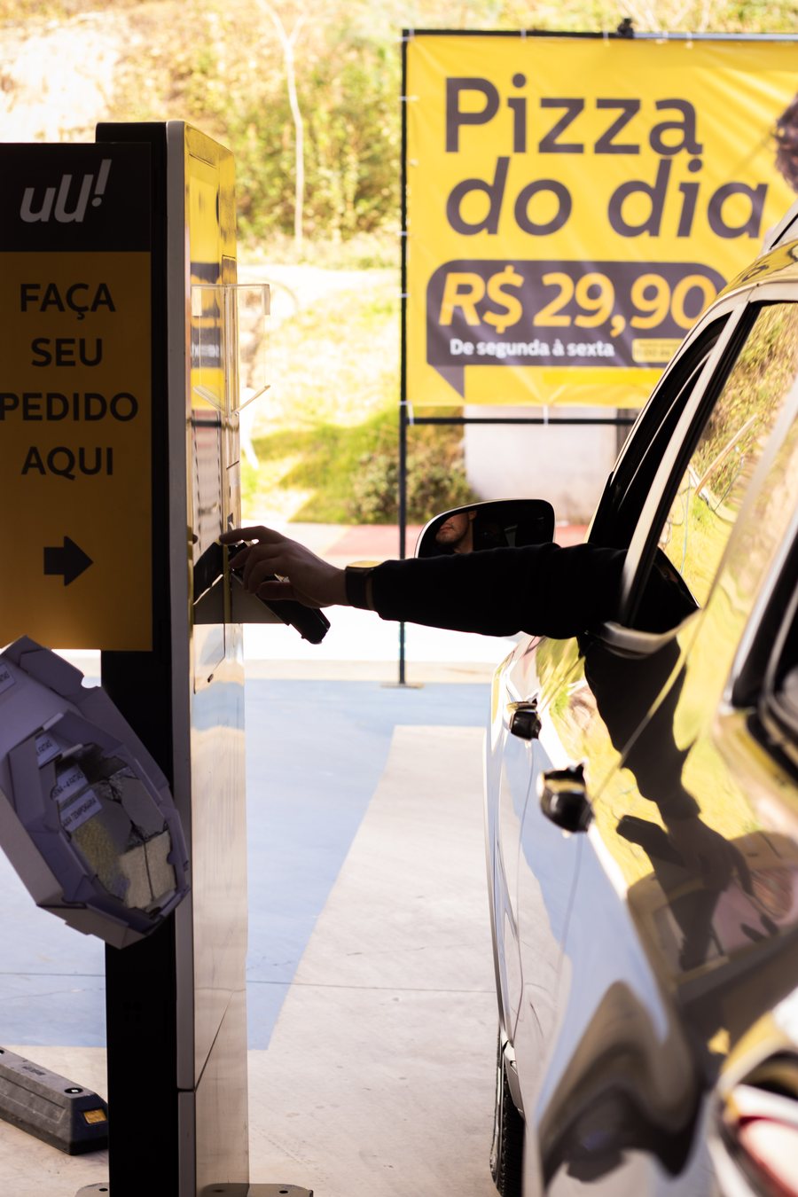 Cliente fazendo o pedido no totem do drive-thru sem sair do carro